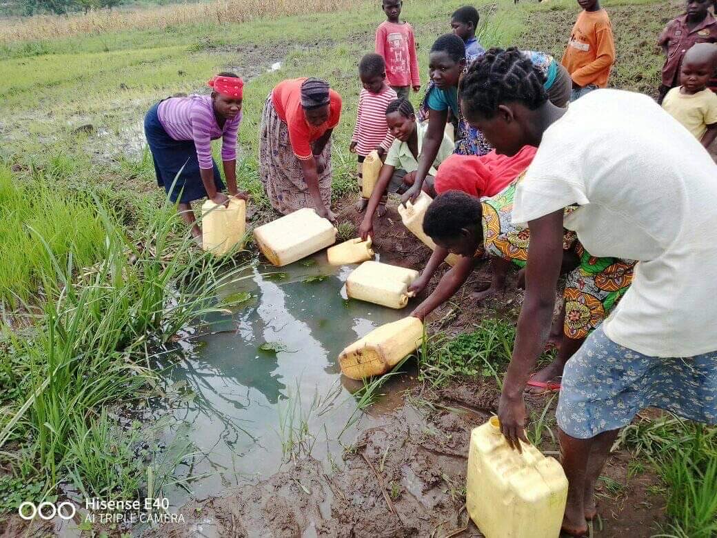 Families collecting water at a Care For Humanity project